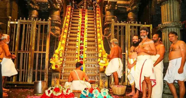 Priests conduct the sacred Padi Puja at the revered 18 Holy Steps of Sabarimala, adorned with flowers and lamps, during the auspicious Mandala–Makaravilaku season.