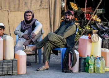 Pakistani men selling petrol wait for customers at their stall in the Pakistan–Iran border town of Taftan