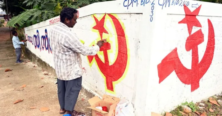 CPI(M) workers paint the party’s hammer and sickle symbol on a roadside wall as part of election campaign preparations in Kerala
