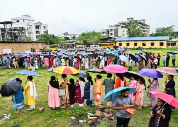 Guwahati [Assam], Apr 09 (ANI): Voters queue up as they wait to cast their votes amid rain at the polling station during the Assam Assembly Elections 2026 in Guwahati on Thursday. (ANI Photo)