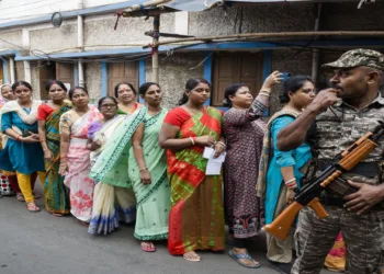 Kolkata, Apr 29 (ANI): A security personnel stand guard as voters wait in a queue outside a polling station to cast their votes for the second phase of West Bengal Assembly Elections 2026, in Kolkata on Wednesday. (ANI Photo)
