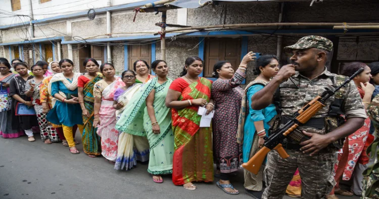 Kolkata, Apr 29 (ANI): A security personnel stand guard as voters wait in a queue outside a polling station to cast their votes for the second phase of West Bengal Assembly Elections 2026, in Kolkata on Wednesday. (ANI Photo)