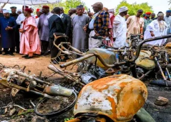 Residents stand near burned buildings after an attack by Islamic State-linked terrorists in Guyaku, Adamawa state, northeastern Nigeria, where at least 29 people were killed
