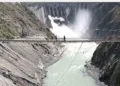 Labours walking on the bridge on top of the river Chenab