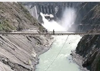 Labours walking on the bridge on top of the river Chenab