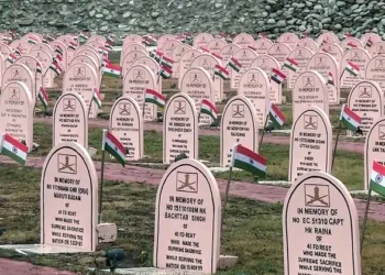 Drass, Jul 25 (ANI): A view of rows of memorial headstones adorned with National flags as preparations underway ahead of the 27th Kargil Vijay Diwas on July 26, in Drass on Saturday. (ANI Video Grab)