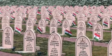 Drass, Jul 25 (ANI): A view of rows of memorial headstones adorned with National flags as preparations underway ahead of the 27th Kargil Vijay Diwas on July 26, in Drass on Saturday. (ANI Video Grab)