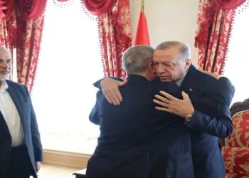Turkish President Recep Tayyip Erdogan meets a Hamas delegation in Turkey as the late Hamas political chief Ismail Haniyeh (left) looks on
