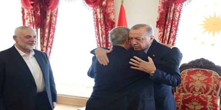 Turkish President Recep Tayyip Erdogan meets a Hamas delegation in Turkey as the late Hamas political chief Ismail Haniyeh (left) looks on