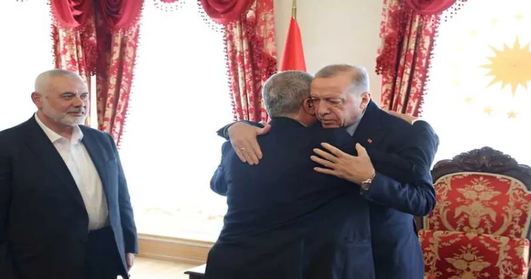 Turkish President Recep Tayyip Erdogan meets a Hamas delegation in Turkey as the late Hamas political chief Ismail Haniyeh (left) looks on