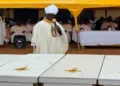 A Christian cleric addresses mourners during a funeral service beside the coffins of victims killed in recent attacks in Nigeria's Middle Belt