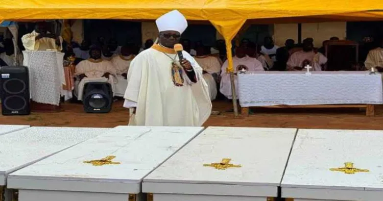 A Christian cleric addresses mourners during a funeral service beside the coffins of victims killed in recent attacks in Nigeria's Middle Belt