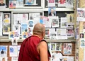 A Buddhist Monk looking at the pictures of lost and missing people outside Tribhuvan University Teaching Hospital