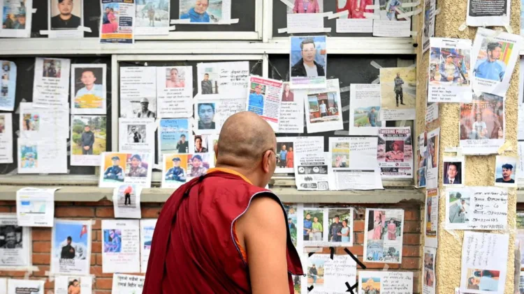A Buddhist Monk looking at the pictures of lost and missing people outside Tribhuvan University Teaching Hospital
