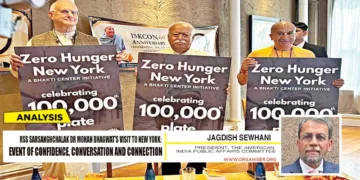 Sarsanghchalak Mohan Bhagwat visited ISKCON in New York on August 28. He poses for a picture holding a placard for the "Zero Hunger New York" initiative by the Bhakti Centre. Minister of Communications and Governing Body Commissioner of ISKCON, Anuttama Dasa (L) also present