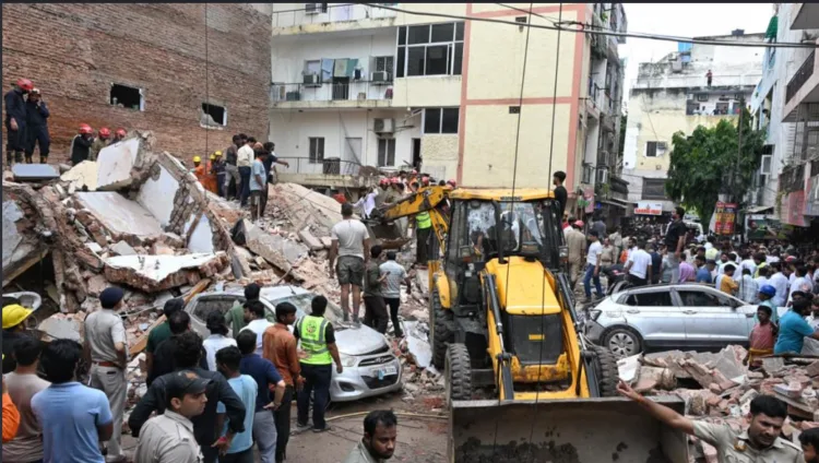 Rescue teams clear debris at the Satya Niketan building collapse site in Delhi