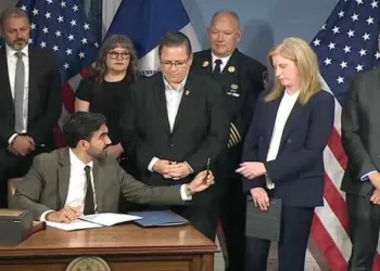 Mayor Mamdani asks Police Commissioner Jessica Tisch to pass the ceremonial 9/11 pen to his chief counsel Ramzi Kassem (extreme right)