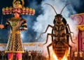 A giant cockroach effigy burns alongside a towering Ravana during Dussehra celebrations in Delhi, drawing crowds