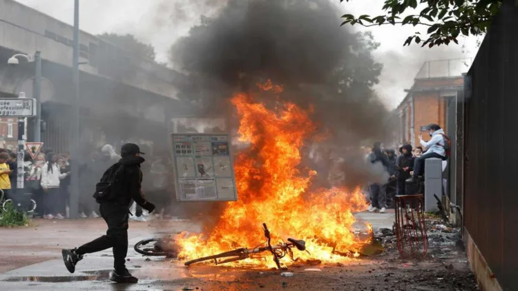 A student walks past a burning bicycle next to the Baggio High School Tuesday, Sept. 29, 2026, in Lille, France