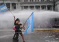 Left-wing protesters wave Argentine flags as police deploy water cannons outside Congress in Buenos Aires during the protest against university funding cuts