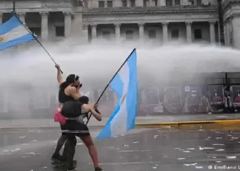 Left-wing protesters wave Argentine flags as police deploy water cannons outside Congress in Buenos Aires during the protest against university funding cuts