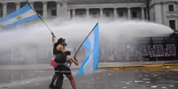 Left-wing protesters wave Argentine flags as police deploy water cannons outside Congress in Buenos Aires during the protest against university funding cuts