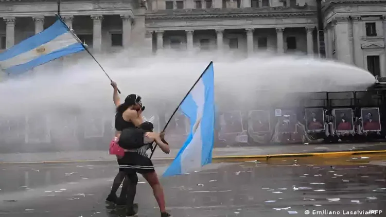 Left-wing protesters wave Argentine flags as police deploy water cannons outside Congress in Buenos Aires during the protest against university funding cuts